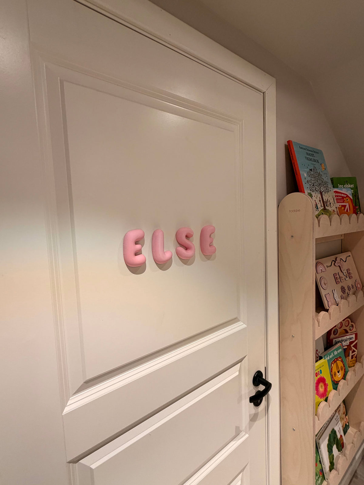 Navnet ELSE i rosa Bubble Letters på en hvit dør