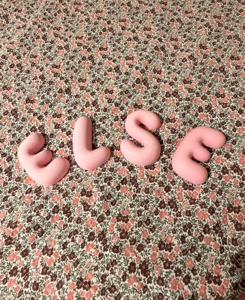 Rosa Bubble Letters som staver ELSE på blomstrete stoff